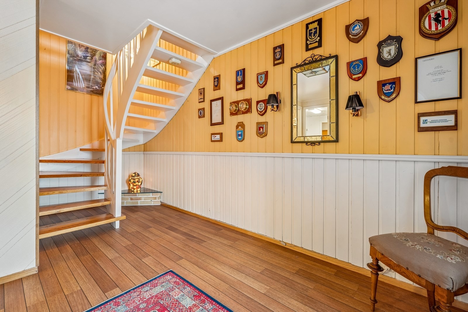 Hallen i underetasjen har ei måla trapp med lakkerte trinn som knyter saman etasjane i bustaden. Galleribilde