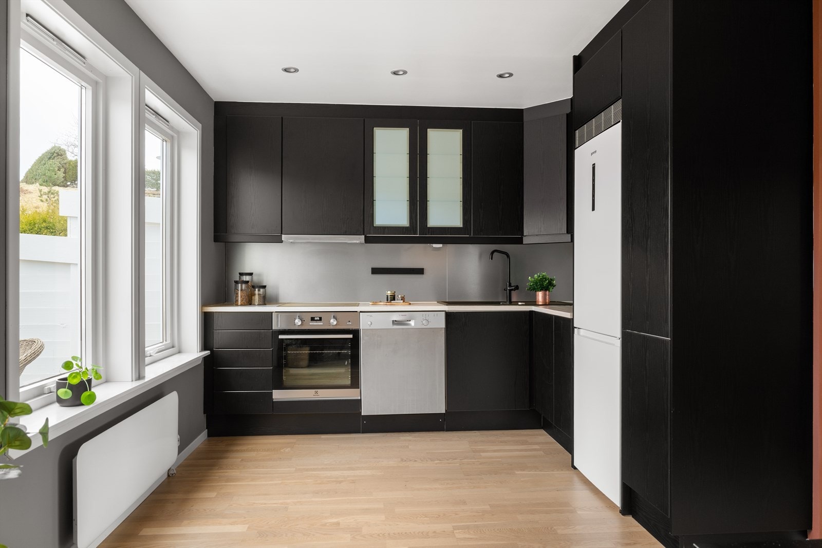 Kjøkkenet har en moderne utførelse med slette fronter og benkeplate av laminat. Både kjøkkeninnredning og benkeplate er foliert i moderne farger. Galleribilde