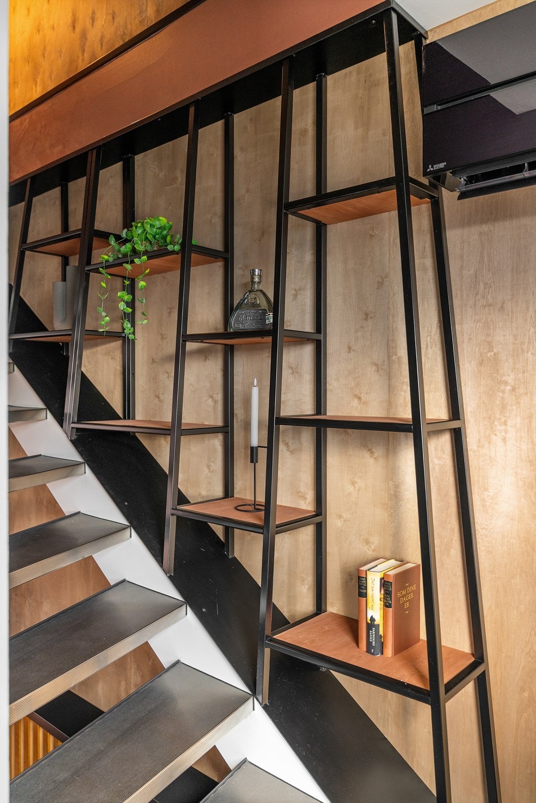 Detalj i trapp mellom 1. etasje og 2. etasje. Også dette er laget av nåværende eier. Hyllen gir et røft og stramt uttrykk som passer til resten av huset. Galleribilde