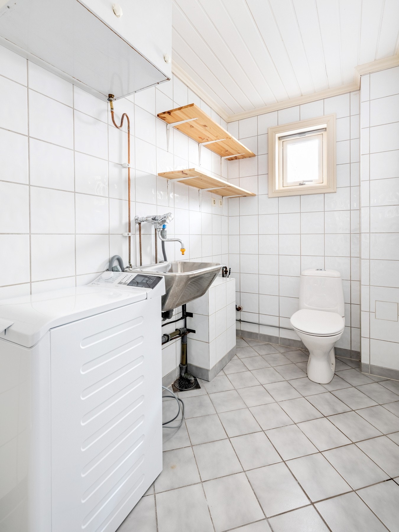 Vaskerommet har flislagte vegger- og gulv, og er innredet med utslagsvask, gulvstående toalett og opplegg for vaskemaskin. Galleribilde