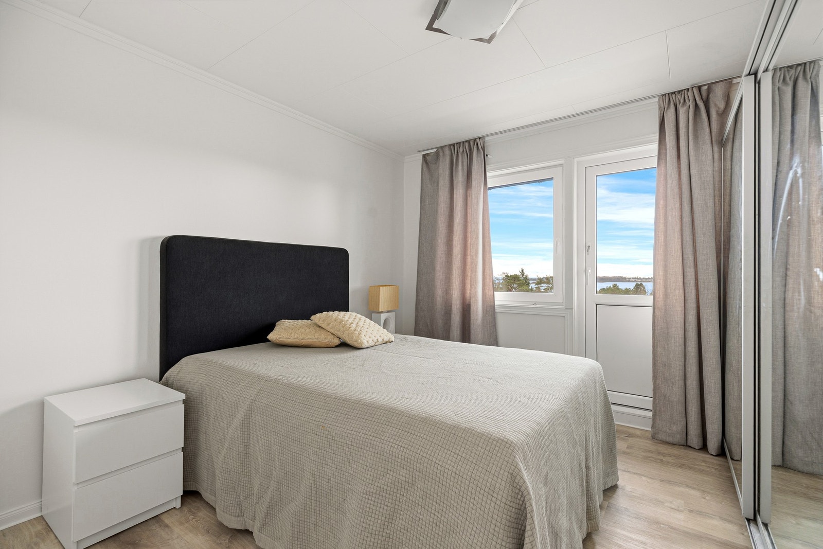 Hovedsoverom med dør ut til terrassen. Flere vinduene og ytterdørene i huset er av nyere dato Galleribilde