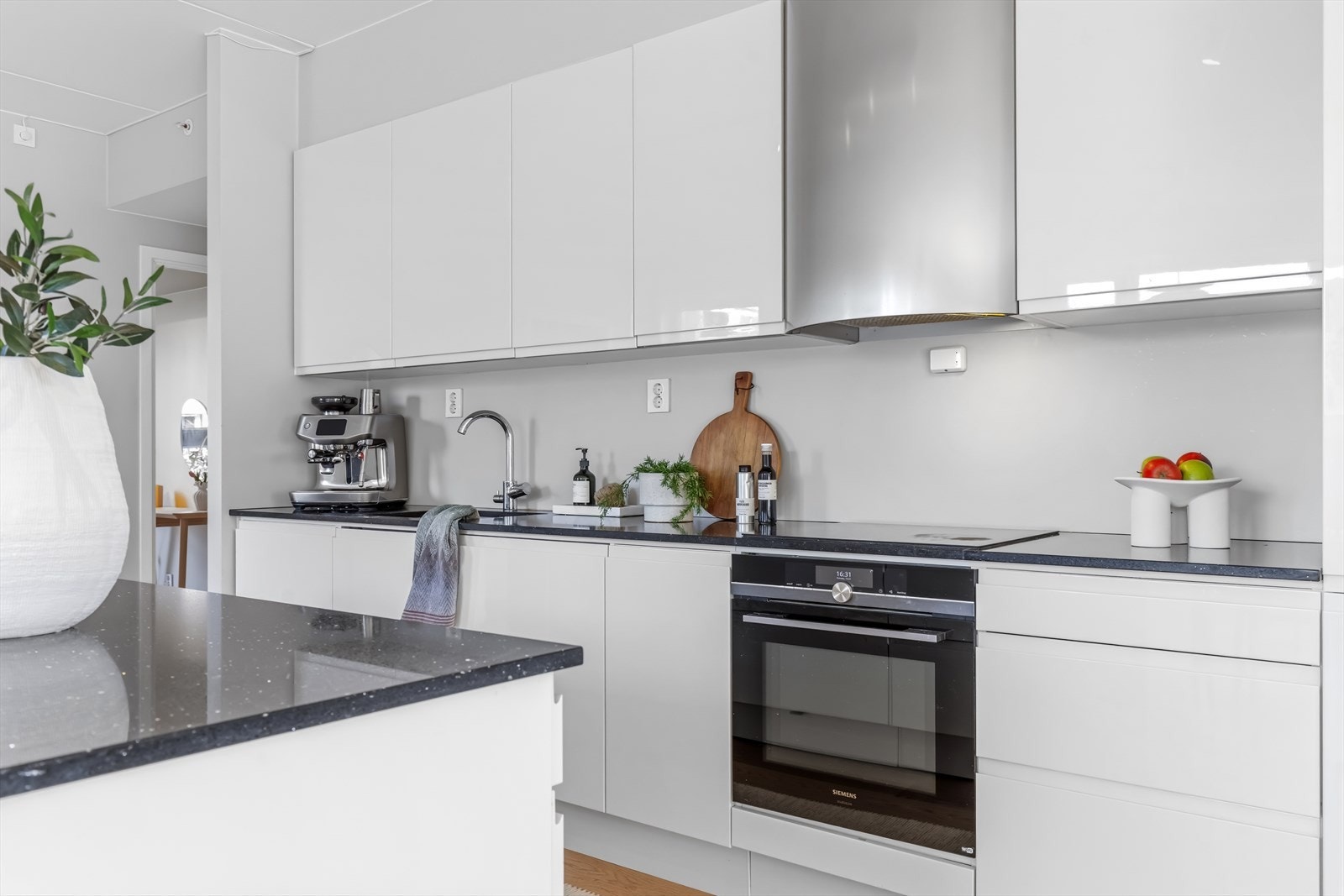 Detalj fra kjøkkenet som viser platetopp og stekeovn. Avtrekket er koblet til boligens balanserte ventilasjonsanlegg. Galleribilde