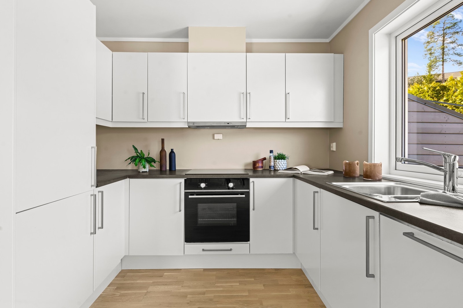 Kjøkkenet er i åpen løsning med stuen og har en moderne innredning fra Sigdal med glatte fronter og laminat benkeplate. Galleribilde