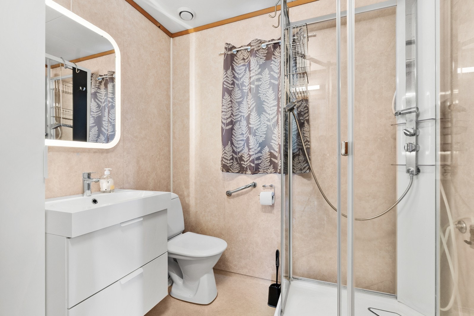 Badet har gulvbelegg på gulv og baderomsplater på vegg. Det er varmekabler i gulv. Badet er innredet med baderomsinnredning med servant, dusjkabinett, toalett og opplegg for vaskemaskin. Galleribilde