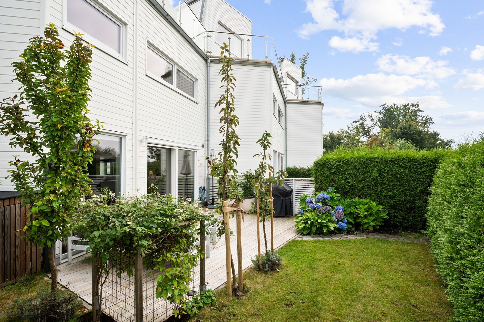 Vestvendt, skjermet terrasseplatting og pent opparbeidet hage. Galleribilde