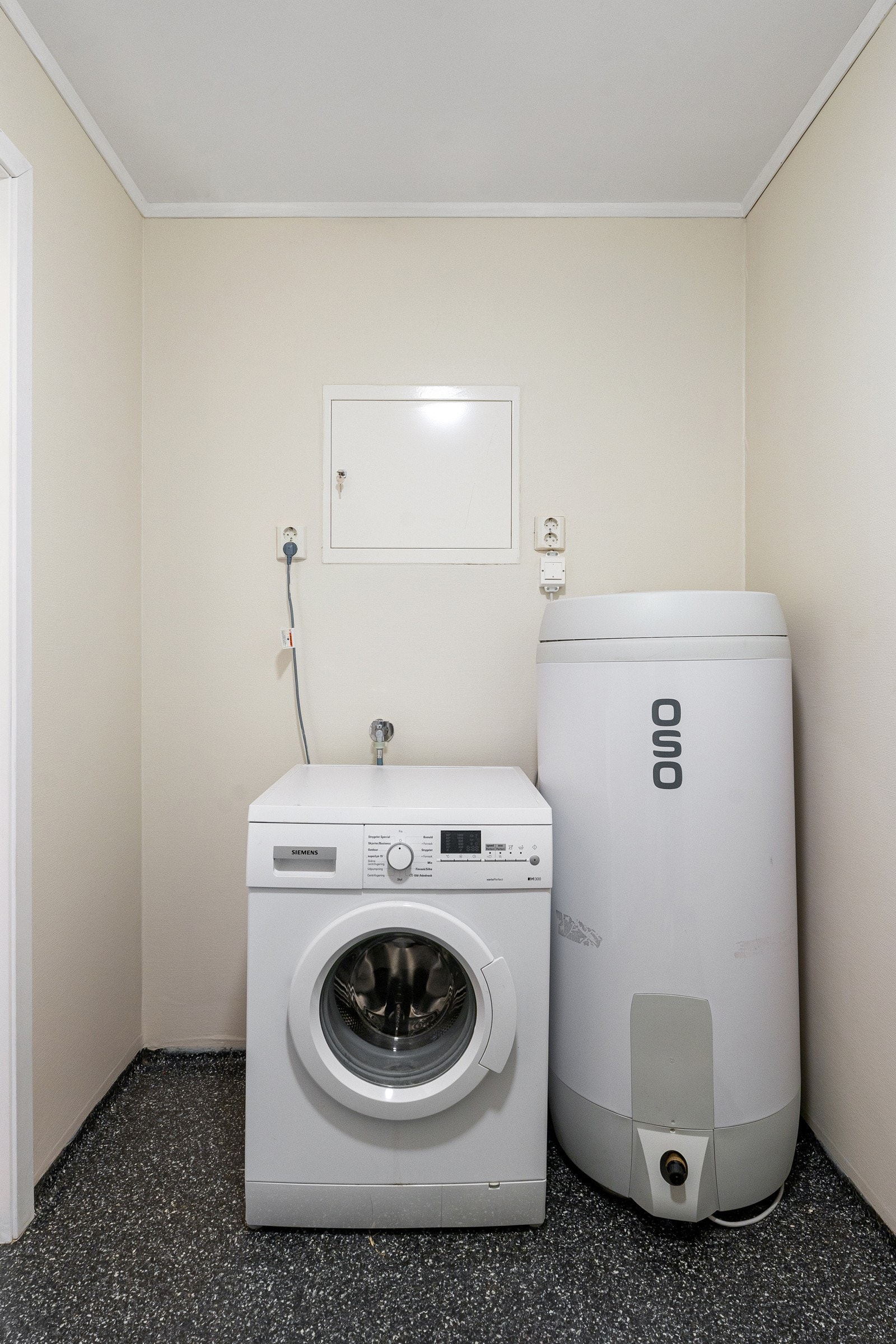 Stort flislagt bad med dusjkabinett og stor innredning for oppbevaring av baderomsartikler.