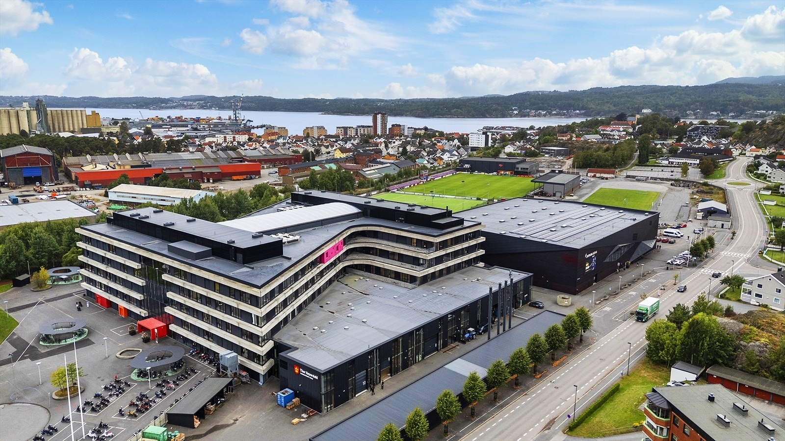 Dronebilde - kort avstand til skoler, barnehager, idrettsanlegg, butikker, sjøen mm. Galleribilde