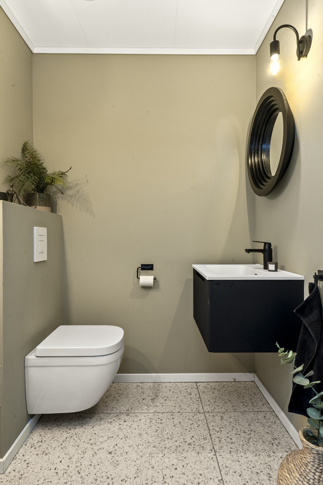 Gjestetoalett i 1. etasje med vegghengt wc og et lite servantskap med overhengende speil. Galleribilde
