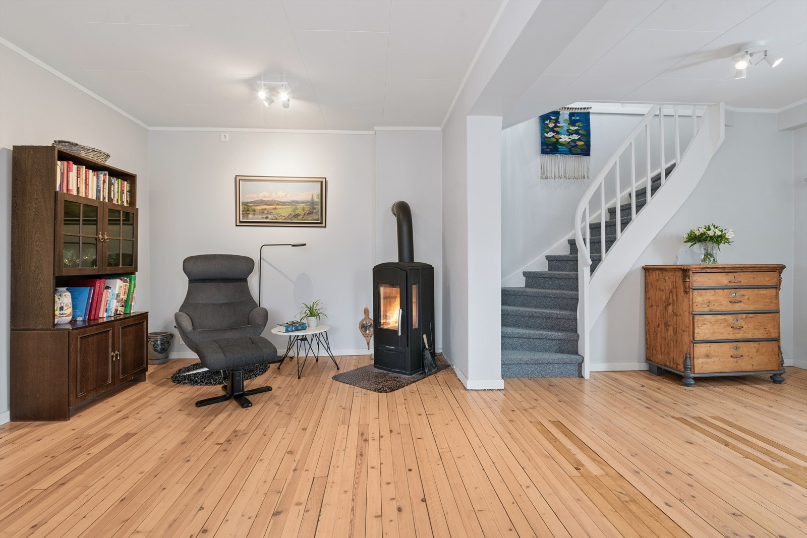 Del av stuen med vedovn - trapp opp til 2. etasje Galleribilde