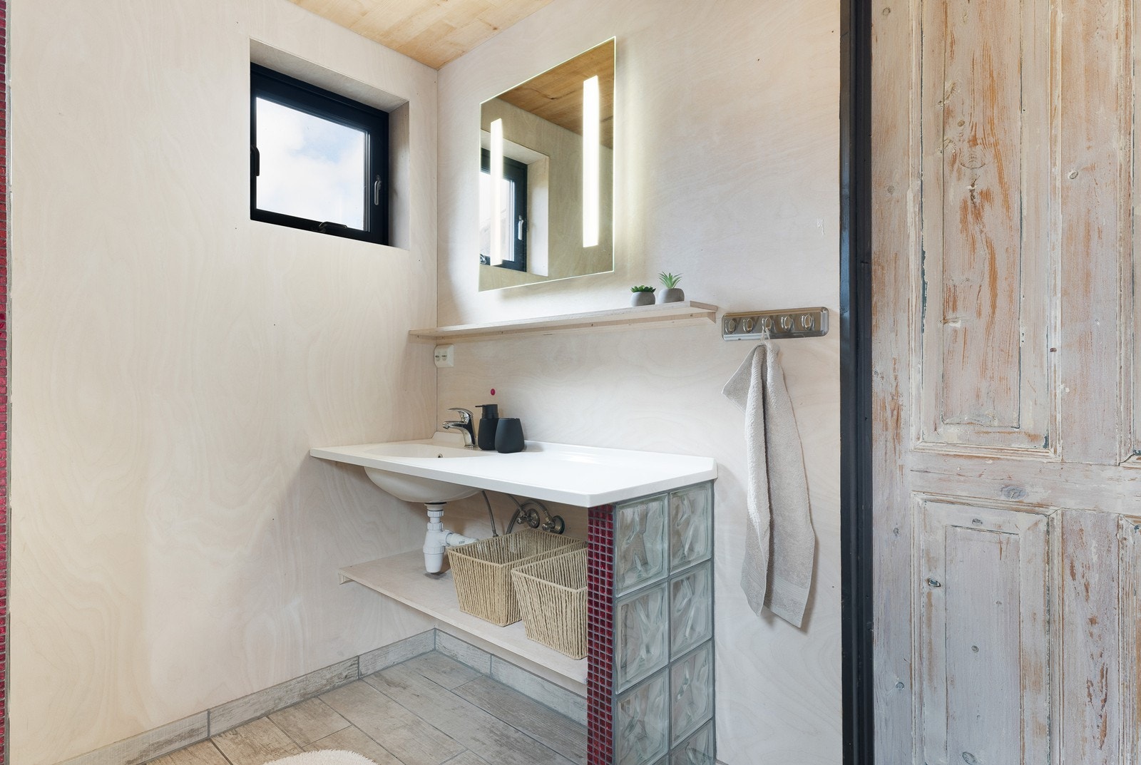 Badet har finerplater på vegger og en inngangsdør med sjel Galleribilde