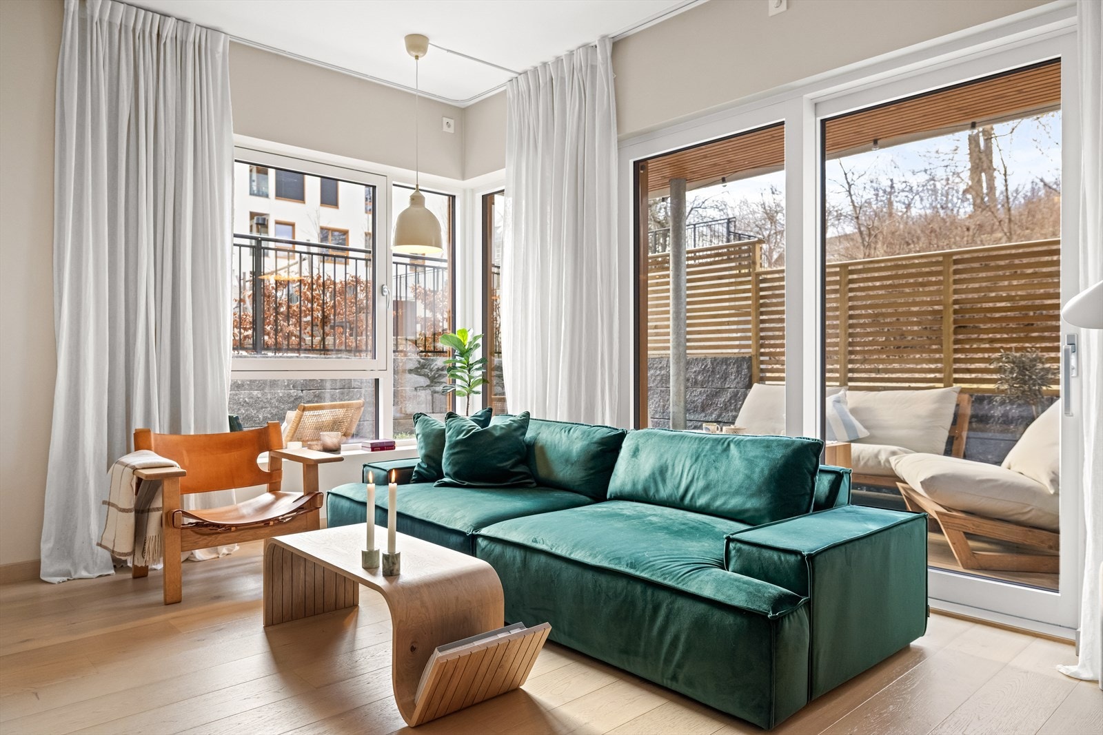 Lys og romslig stue med store vindusflater og utgang til markterrasse Galleribilde