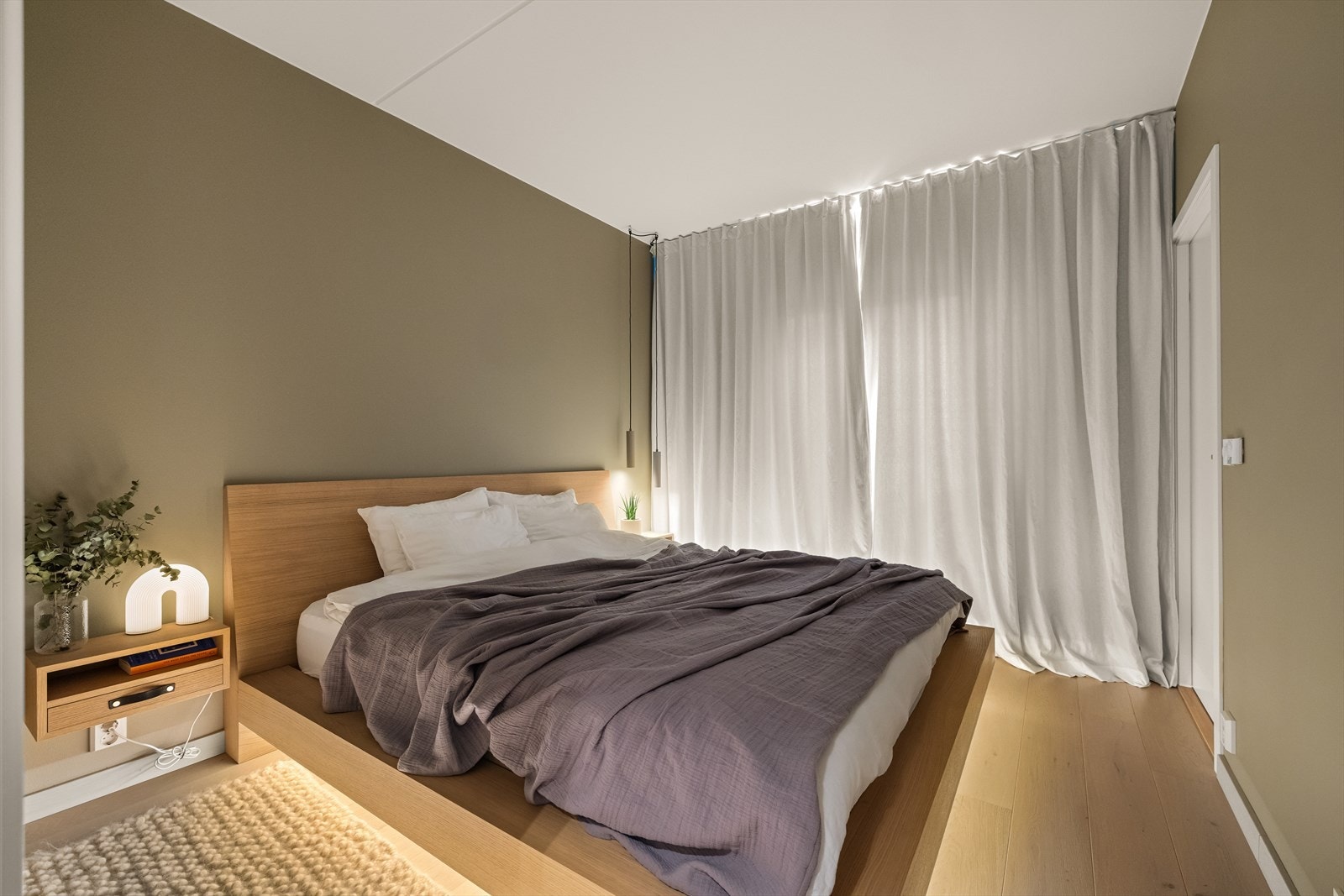 Romslig hovedsoverom med plass til stor dobbeltseng og gjennomgående gardiner som gir et elegant hotellpreg Galleribilde