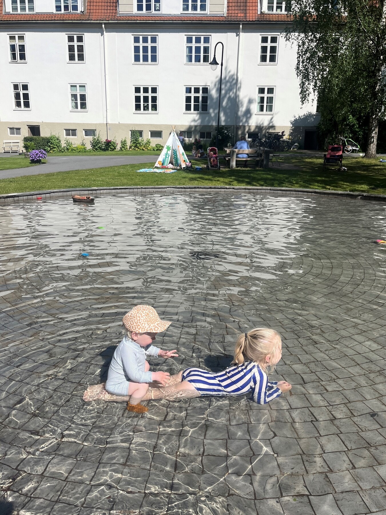 Et stort vannspeil i nabogården, til barnas store glede. Galleribilde