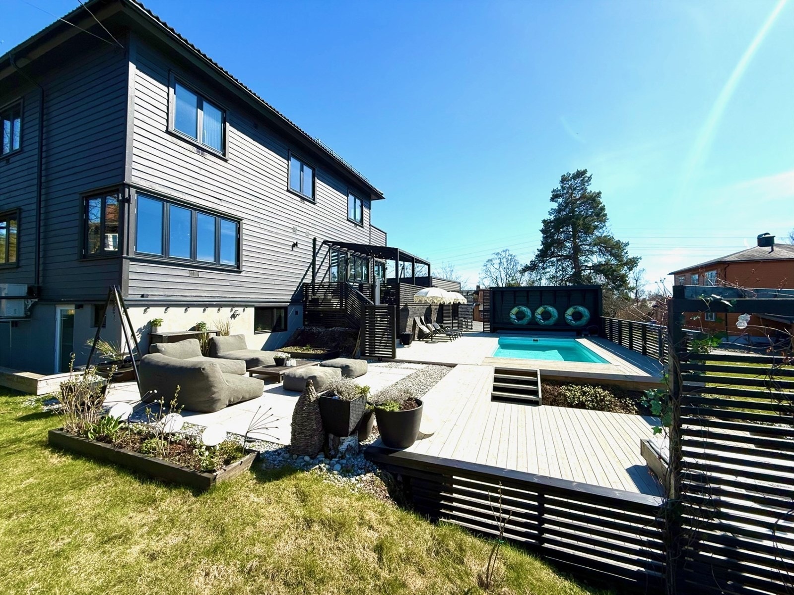 Videre trapp ned til hagen, med gressplen, hekk, beplanting m.m. God plass for lek og aktiviteter for barna i hagen Galleribilde