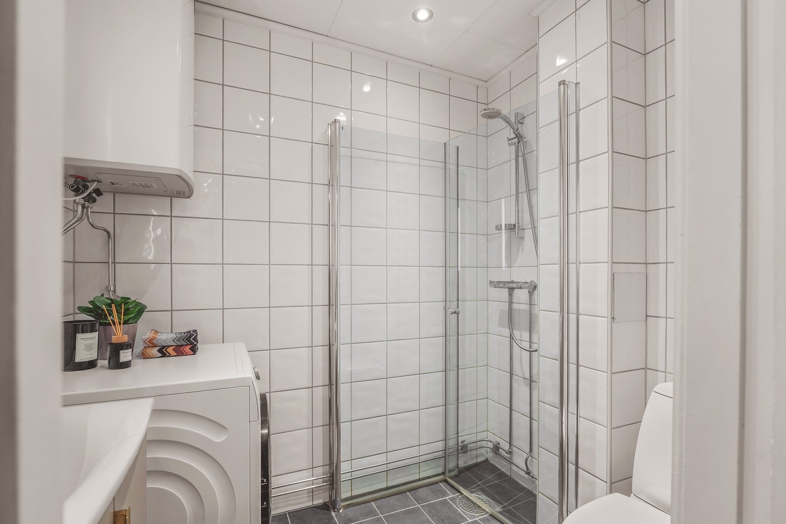 Flislagt bad med grå og hvite fliser på henholdsvis gulv og vegger. Badet ble pusset opp i regi av sameiet i 2005 og fikk nytt gulv inkludert varmekabler i 2015. Galleribilde