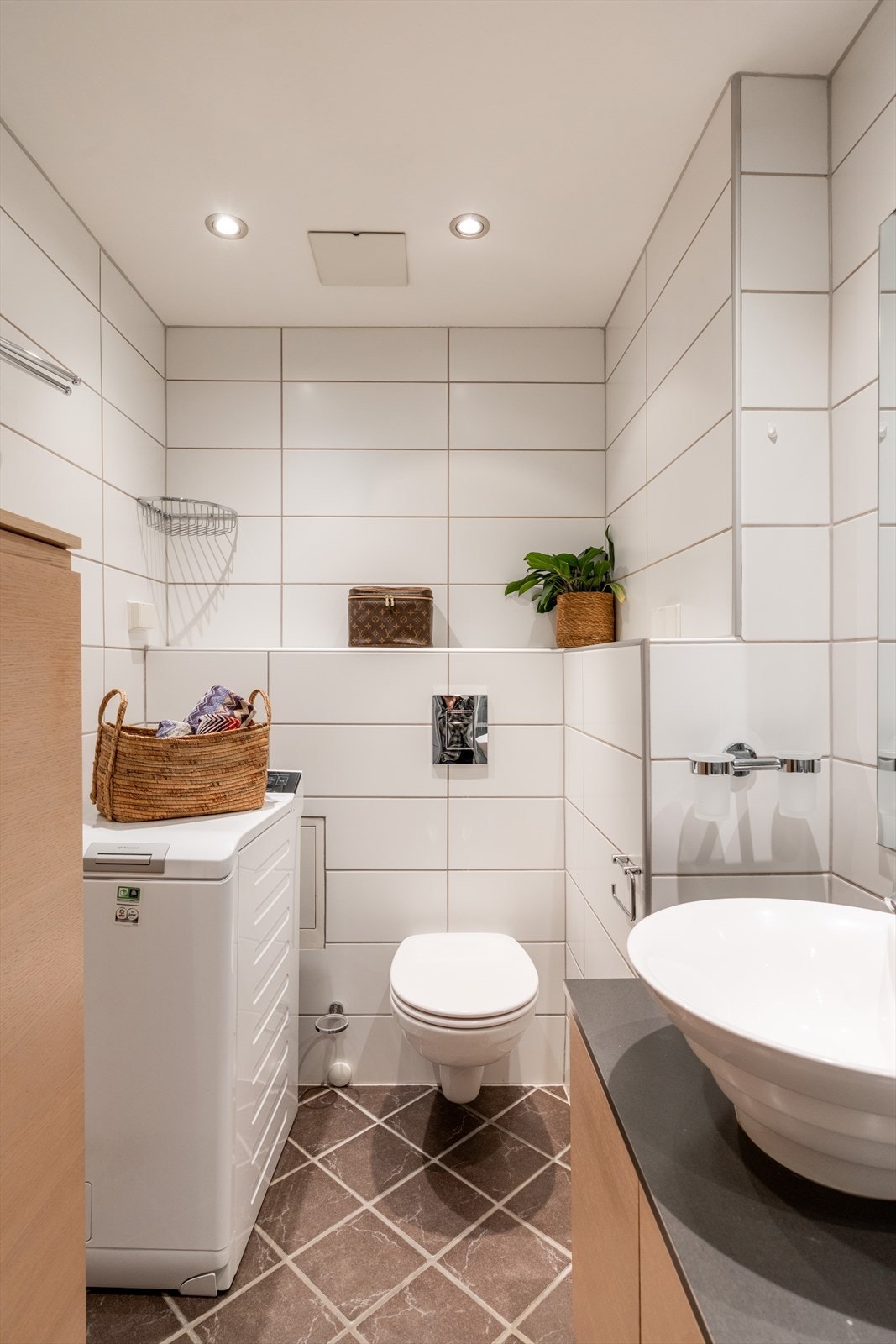 Badet er innredet med vegghengt klosett, servant på innredning og duskjkabinett. Det er opplegg for vaskemaskin. Galleribilde