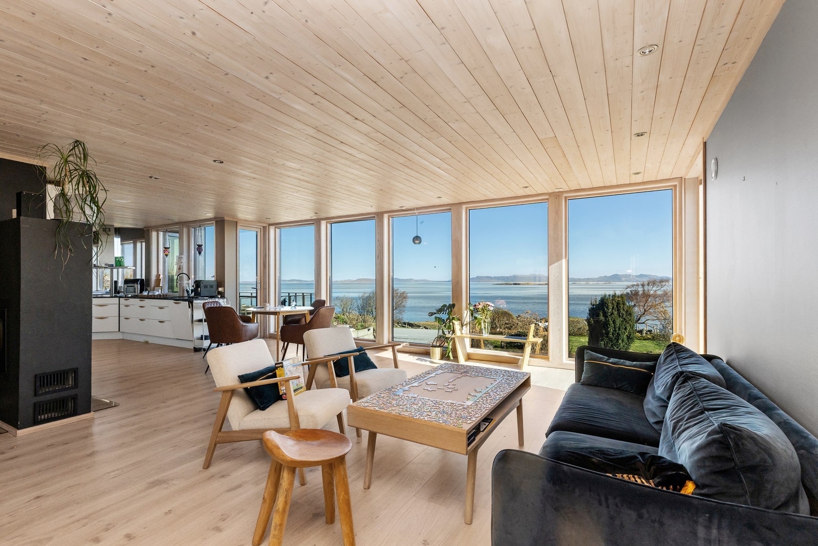 De brede vinduene fra gulv til tak gir en sømløs overgang mellom stuen og det omkringliggende kystlandskapet.
Foto: Marianne Lyse. Galleribilde