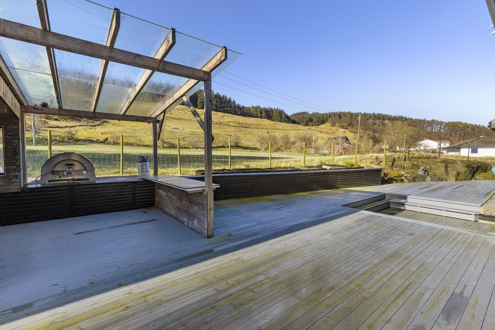 En del av uteplassen har en overbygget pergola, ideell for grilling og bespisning. Pizzaovn medfølger ikke. Pergola med tett tak er ikke omsøkt. Galleribilde