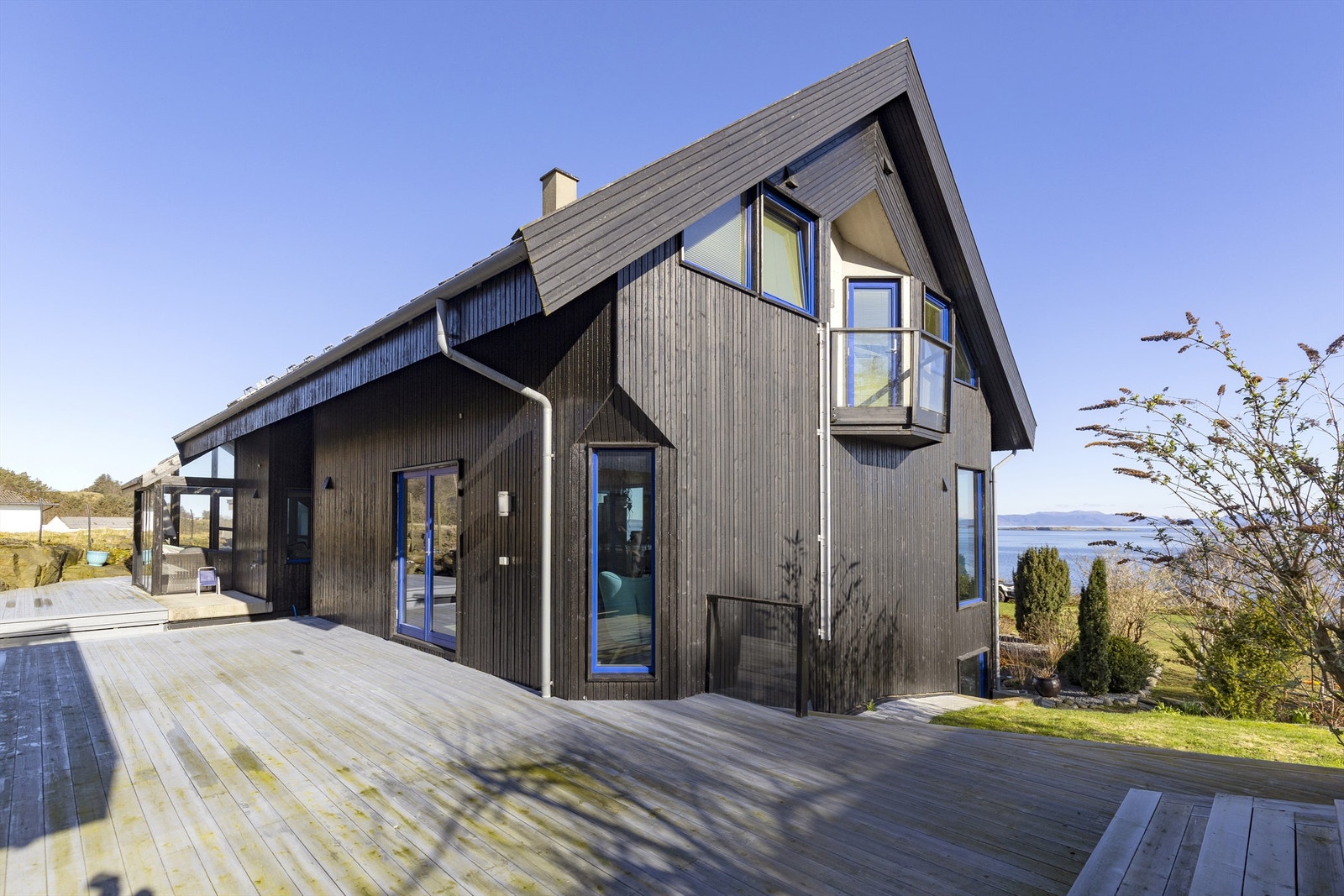 Store terrasseområder i trekonstruksjon omkranser boligen og skaper mange fine uteplasser. Galleribilde