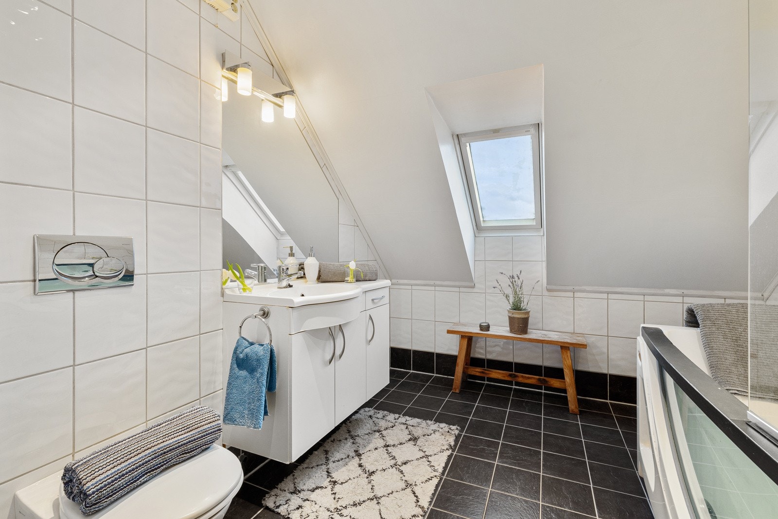 Badet i boligens andre etasje er innredet med vegghengt toalett, servant med underskap, speil med belysning og et frittstående boblebadekar med dusjvegg. Galleribilde