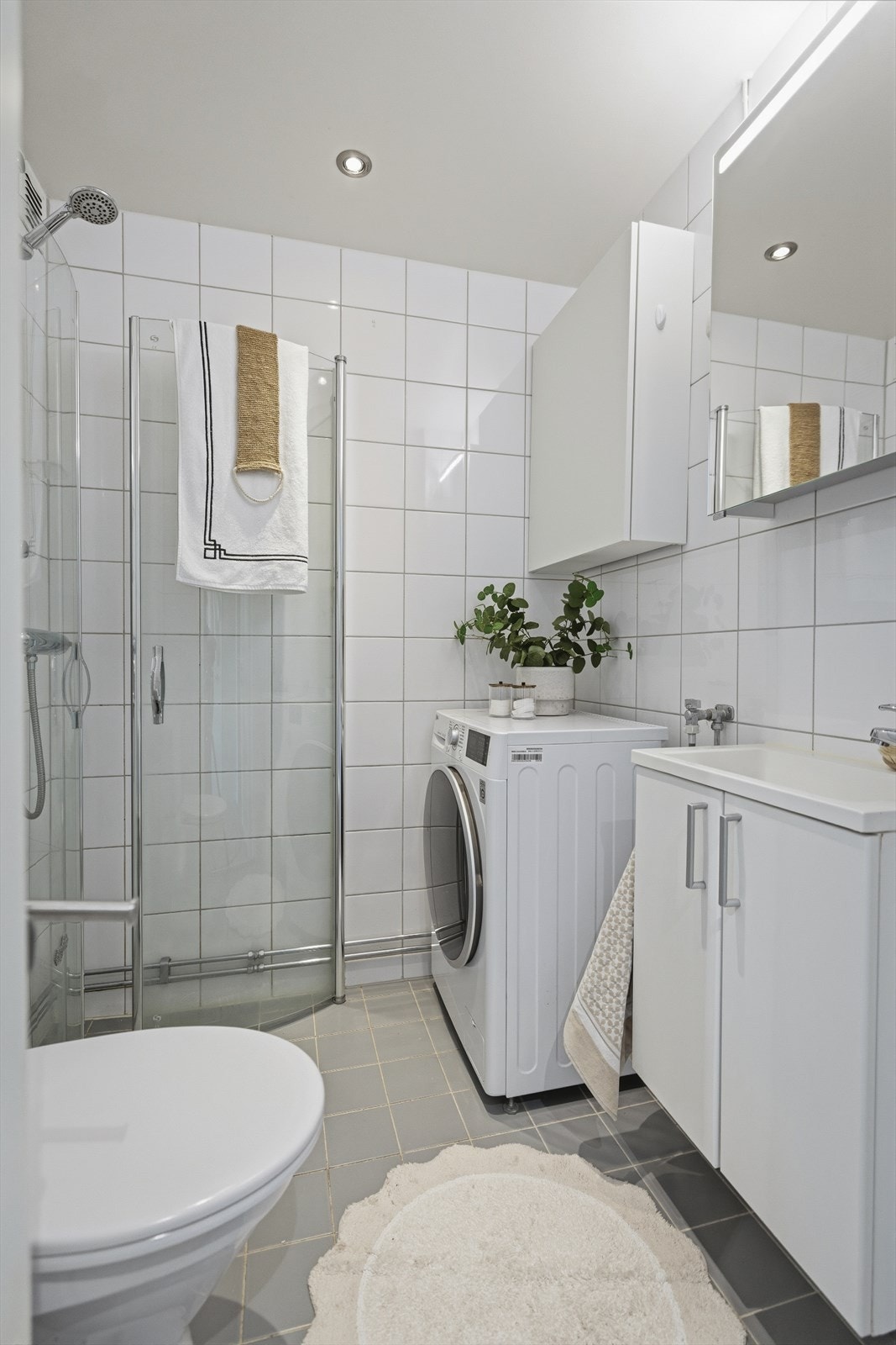 Det er et dusjhjørne med dører i herdet glass og opplegg for vaskemaskin. Ventilasjonen består av naturlig oppdriftsventilasjon med avtrekksventil på vegg og tilluft fra spalte i dør. Galleribilde