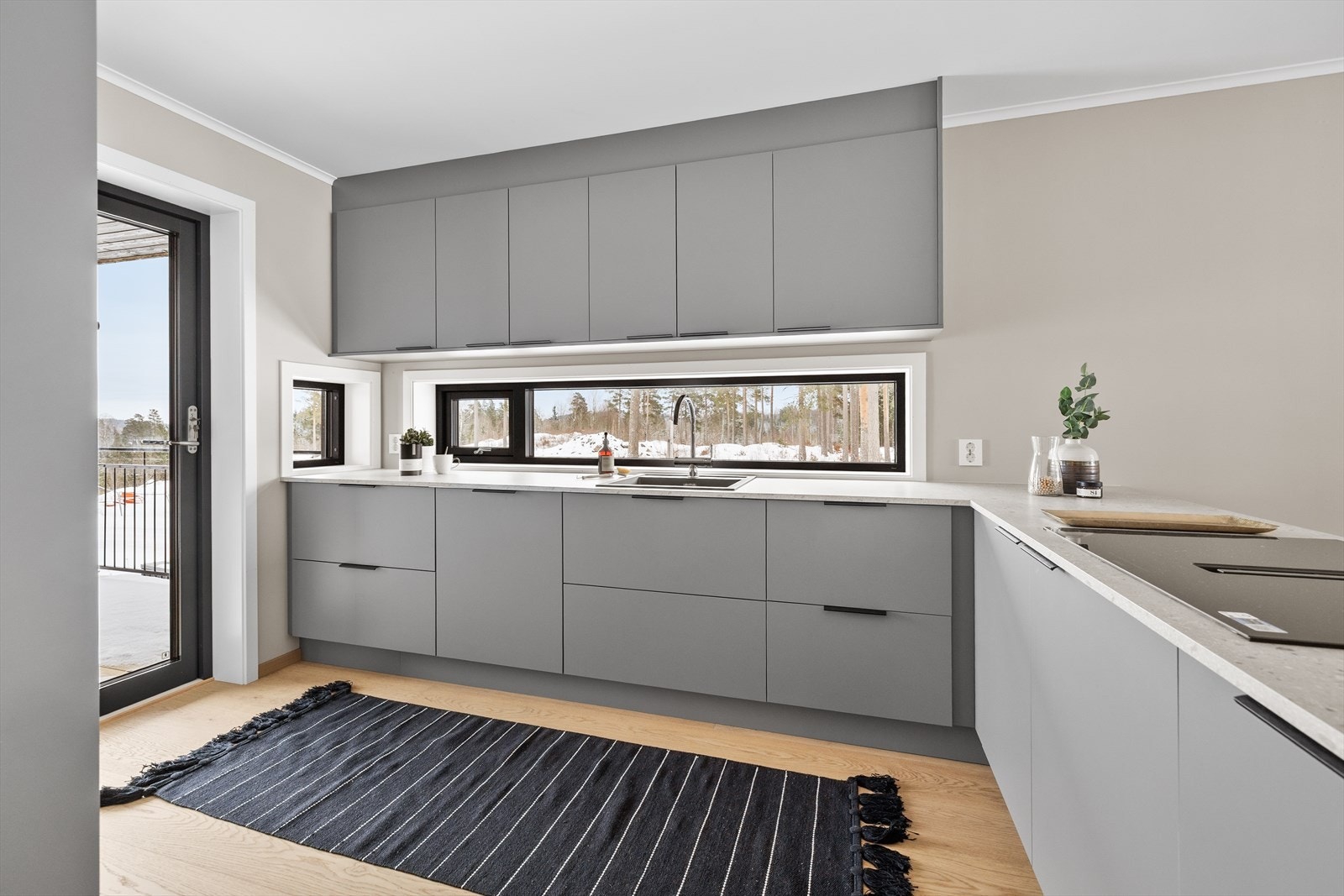 Stilrent kjøkken fra Strai i modellen Dalen i moderne fargetone komplettert med Terrazzo benkeplate og servant og armaturer i sort utførelse. Galleribilde