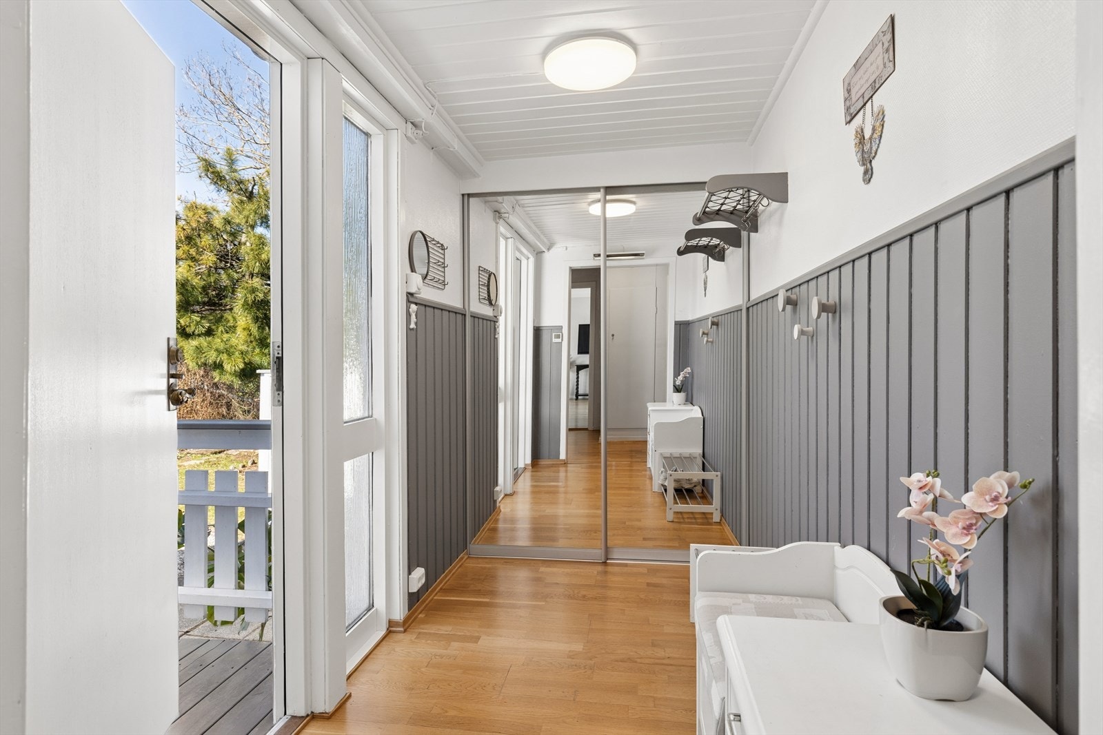 Entréen er romslig og lyst og gir et godt førsteinntrykk. En stor skyvedørsgarderobe med speilfronter gir rikelig med plass til yttertøy og sko. Galleribilde