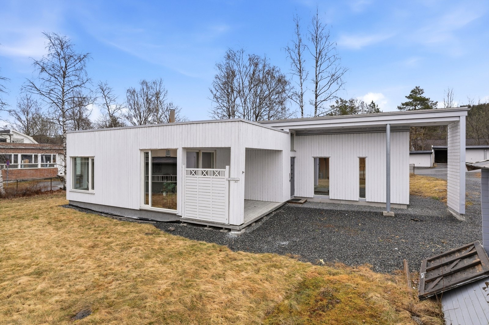 Flat/ lett skrånet tomt, med enkel opparbeidelse. Gressplen og gruset felles gårdsplass. Galleribilde