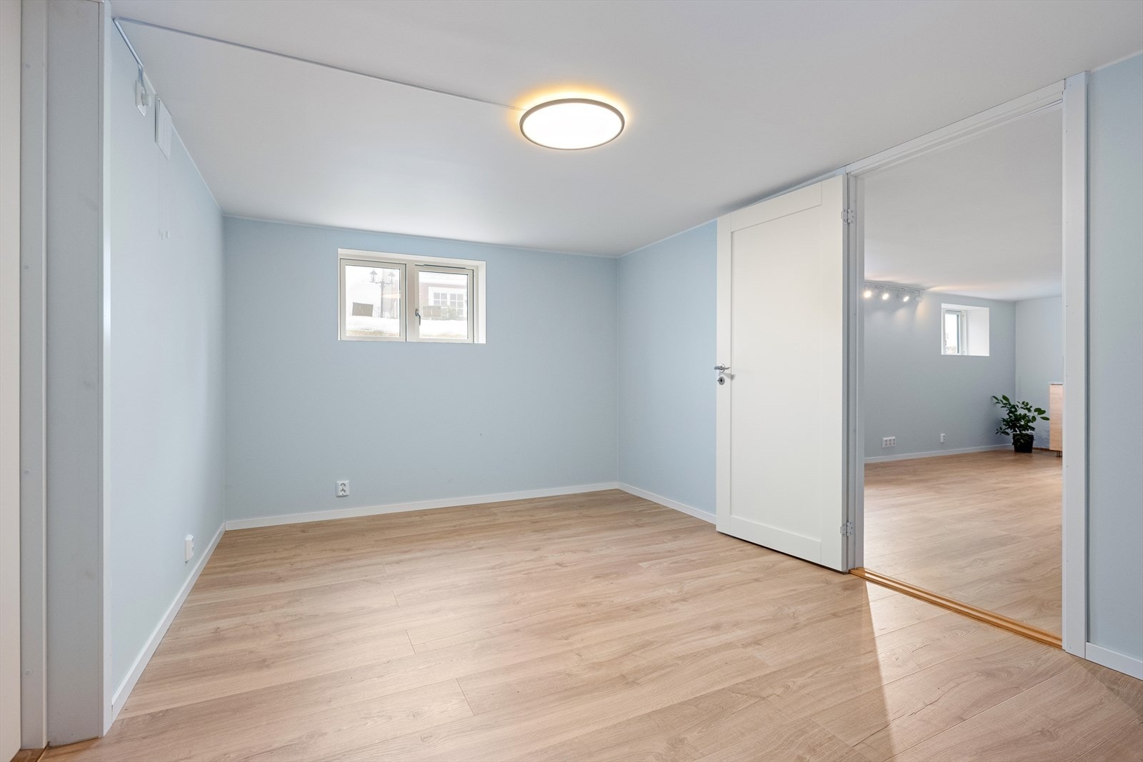 Et annet disponibelt rom i kjelleren, også dette med laminatgulv og lyse vegger. Galleribilde