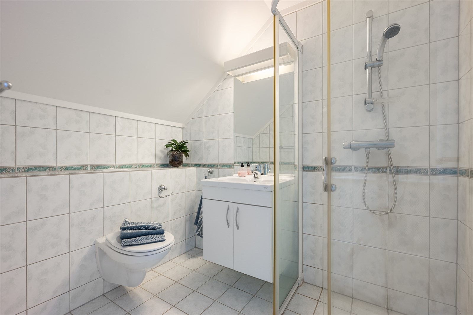 Badet i andre etasje er fra 2005, er flislagt og inneholder dusjhjørne, servant og veggmontert toalett. Galleribilde