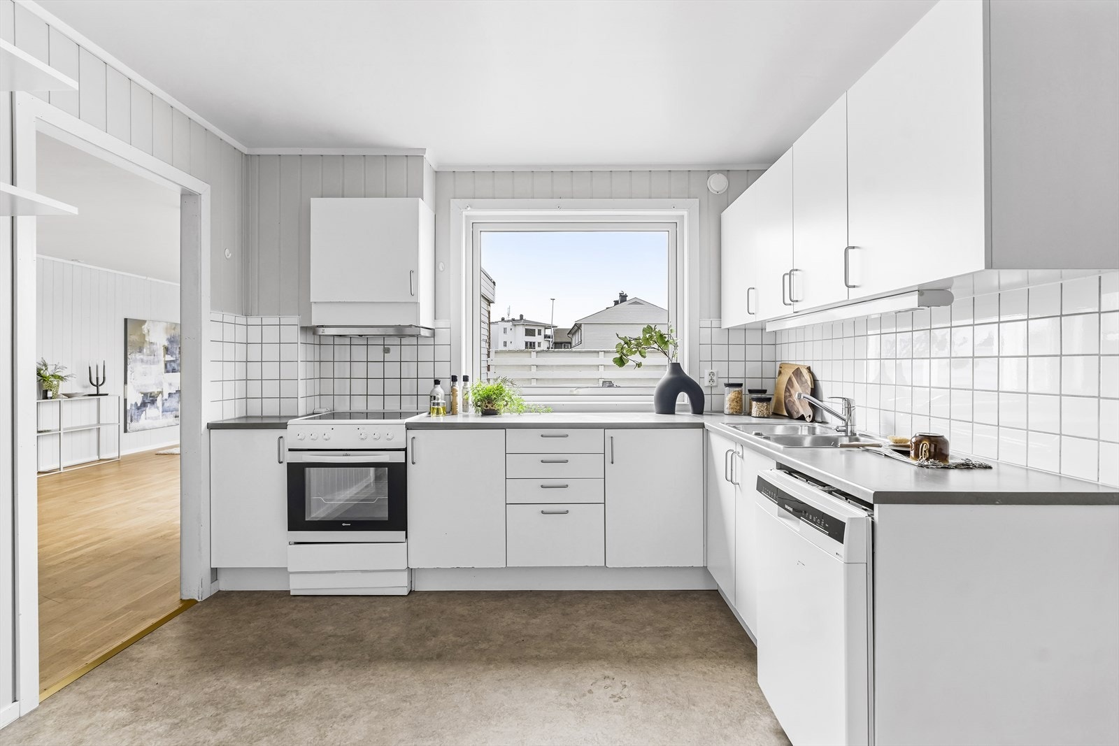 Boligen har et stort, separat kjøkken med hvit, glatt innredning. Galleribilde