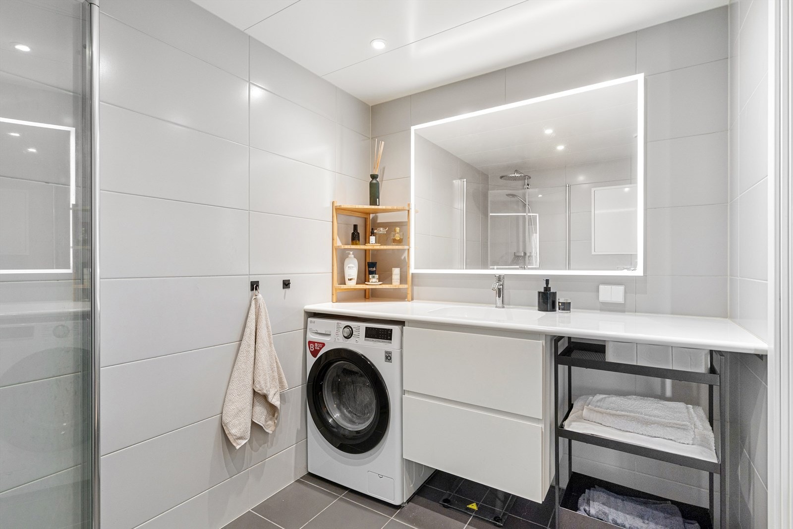 Badet består av veggmontert WC, dusjplass med inn-utadslående dusjvegger, servant med ettgreps blandebatteri i innredning og opplegg for vaskemaskin. Galleribilde
