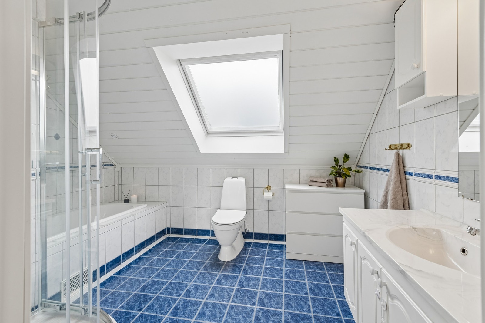 Bad på loft har flislagt bad, dusjkabinett, badekar og god plass til baderomsmøbler. Galleribilde