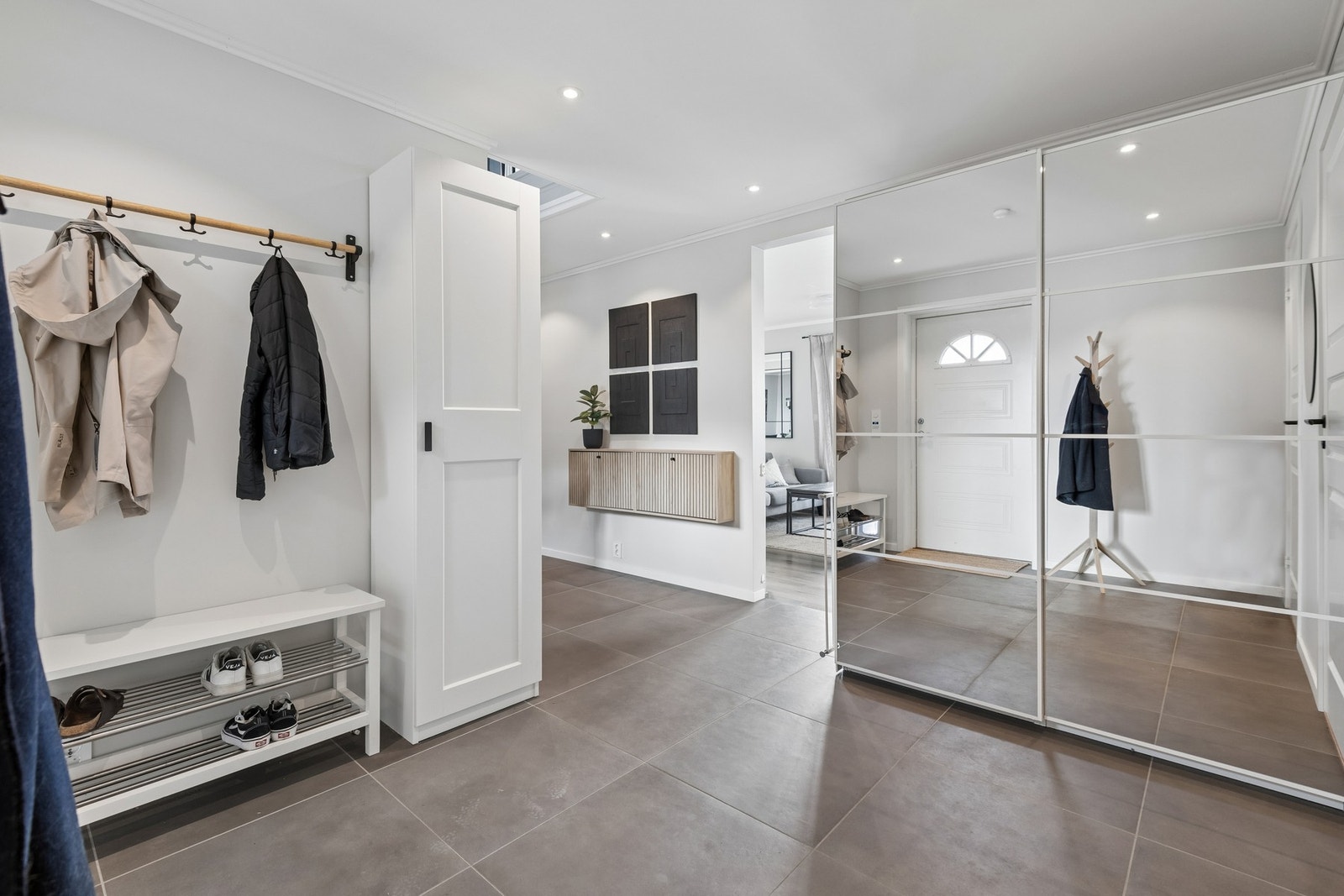 Flislagt gang med praktisks garderobe. Gangen har god plass til å henge fra seg klær og sette sko. Galleribilde