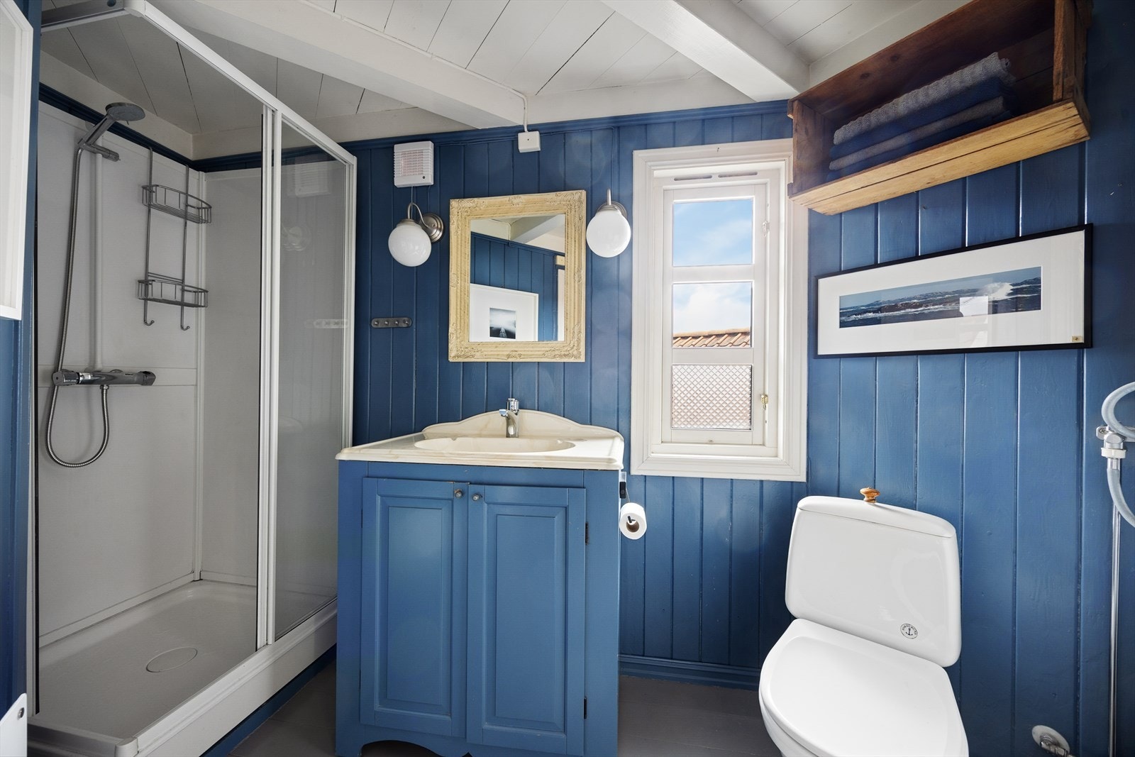 Badet er innredet med dusjkabinett, toalett, servantinnredning med skap og opplegg for vaskemaskin. Det er elektrisk vifte på vegg. Galleribilde
