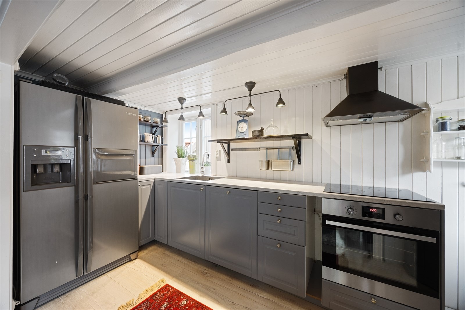 Kjøkkenet har pen innredning fra IKEA med profilerte fronter og laminert benkeplate. Her er det god skap- og benkeplass. Galleribilde