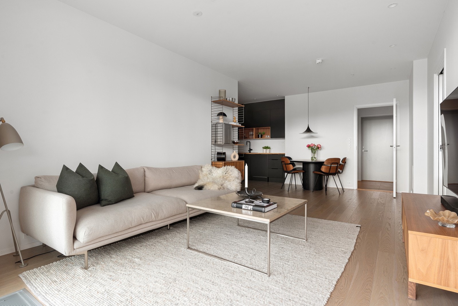 Stue og kjøkken har en åpen planløsning, men rommets utforming gir likevel en naturlig oppdeling mellom sonene.