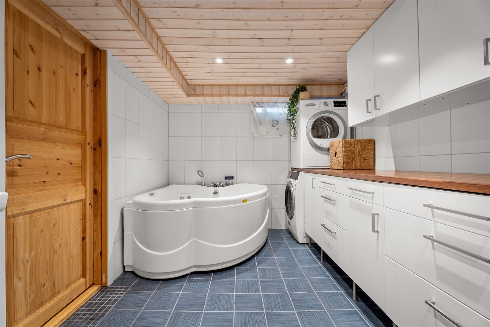 Badet i kjelleren har en praktisk vaskeromsdel med opplegg for vaskemaskin og god benkeplass i laminat. Galleribilde