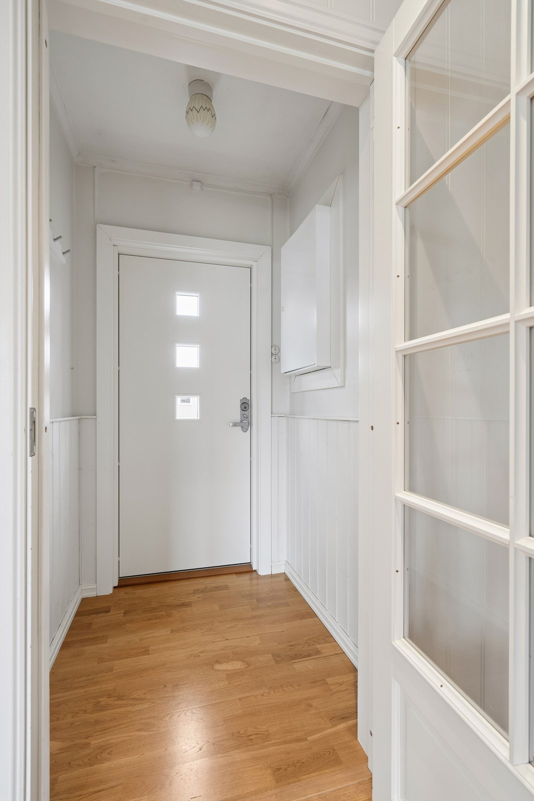 Praktisk vindfang med plass til yttertøy og sko - en funksjonell biinngang til boligen. Galleribilde