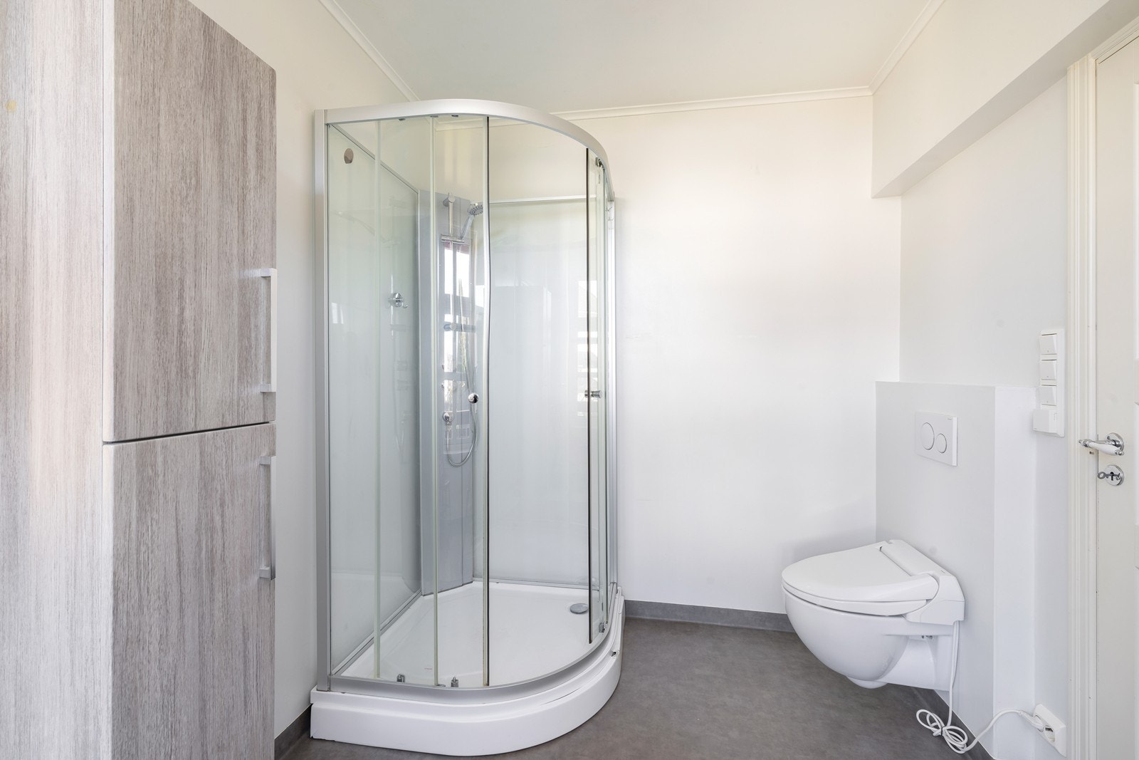 Dusjkabinett og vegghengt wc med spylefunksjon på badet i 1. etg og inngang til soverom. Galleribilde