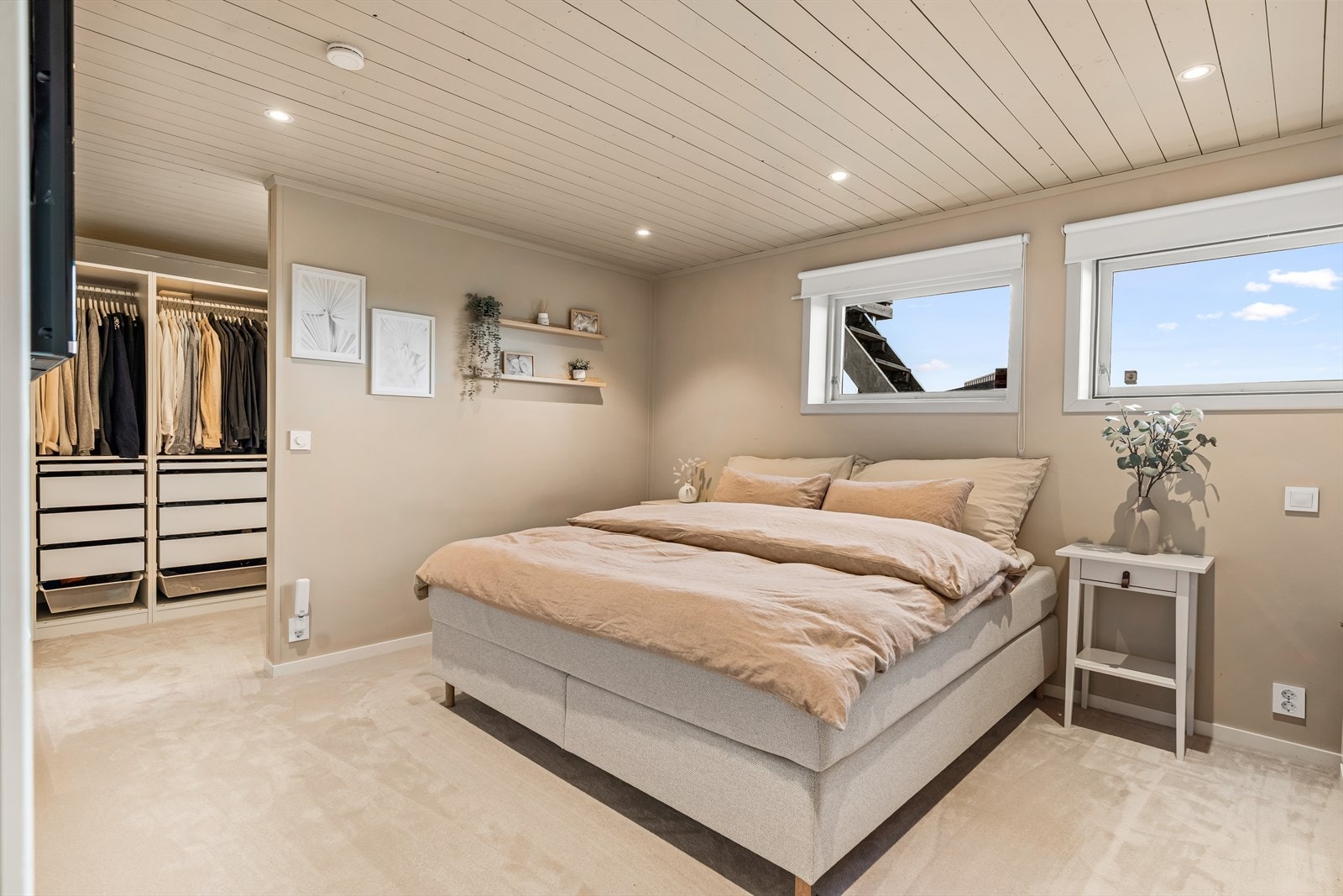 Rommet er innredet med downlights, tv-uttak og lunt teppegulv i lyst design. Galleribilde
