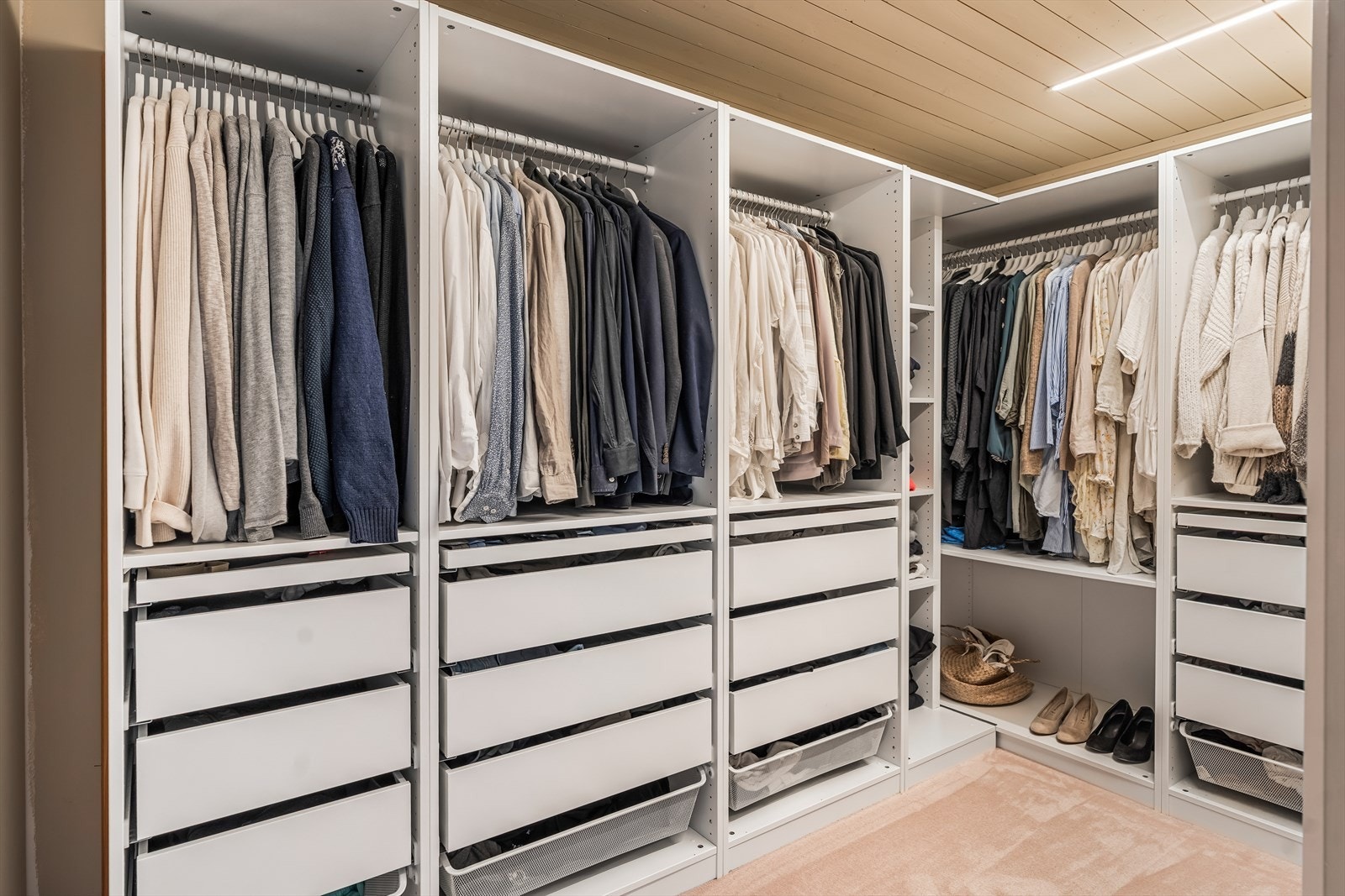 Rommet har et flott walk-in closet med skuffer, hyller og klesoppheng i et stort hjørneskap. Galleribilde