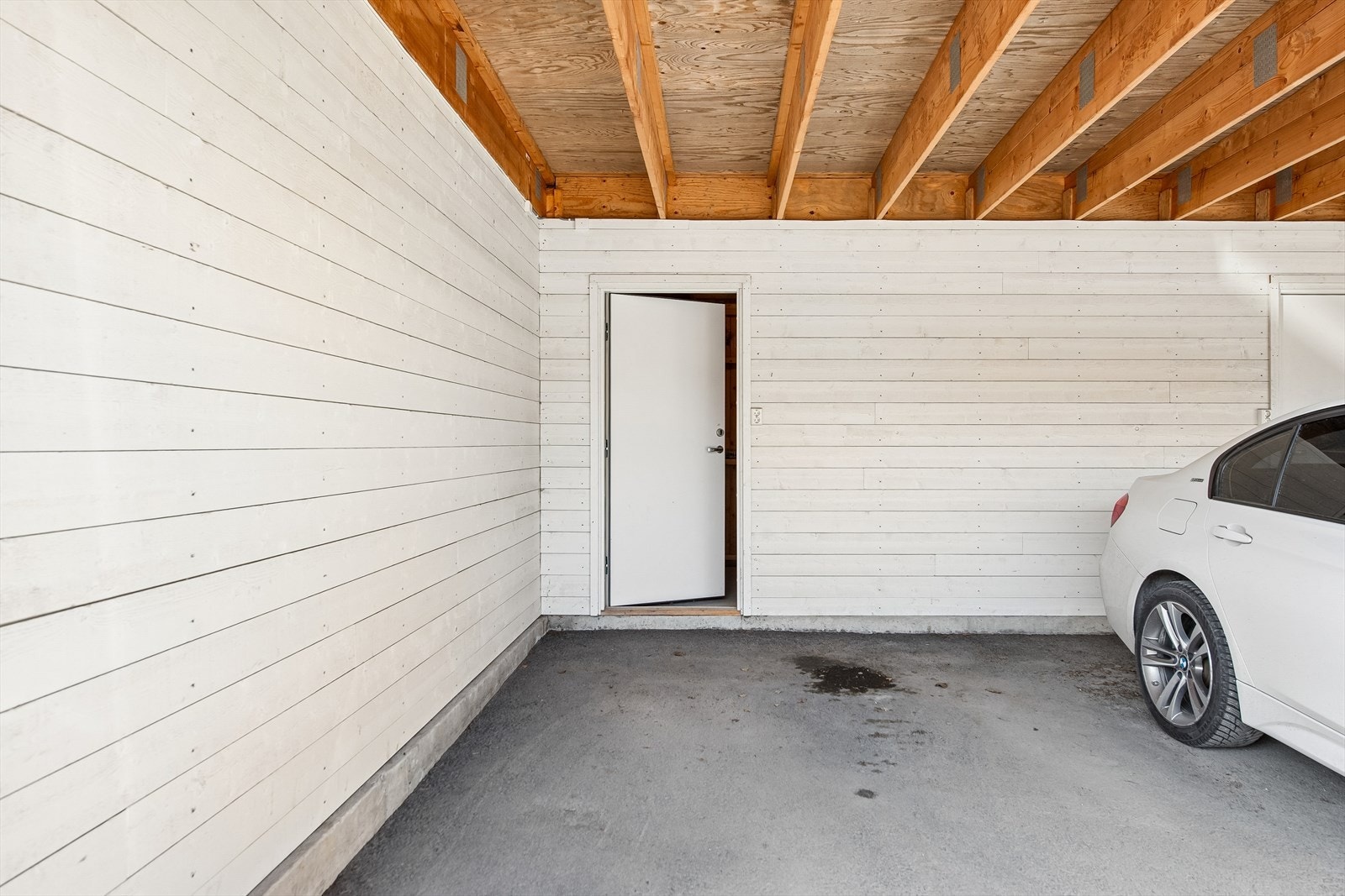 Hver seksjon disponerer sin egen carportplass. Fra carporten er det direkte adkomst til den private uteboden. Galleribilde