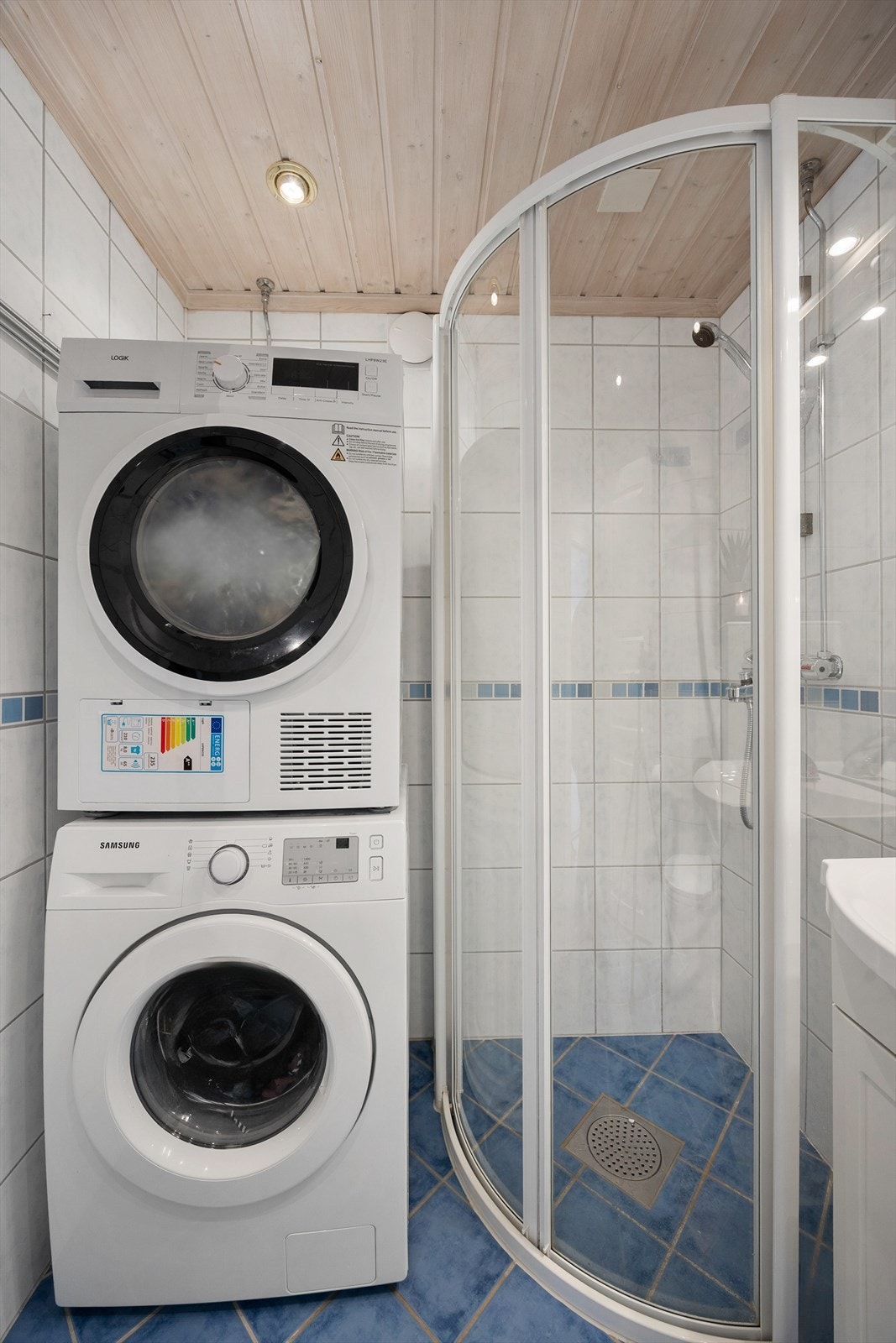 Badet er utstyrt med dusjhjørne og har opplegg for vaskemaskin og tørketrommel i søyle. Galleribilde