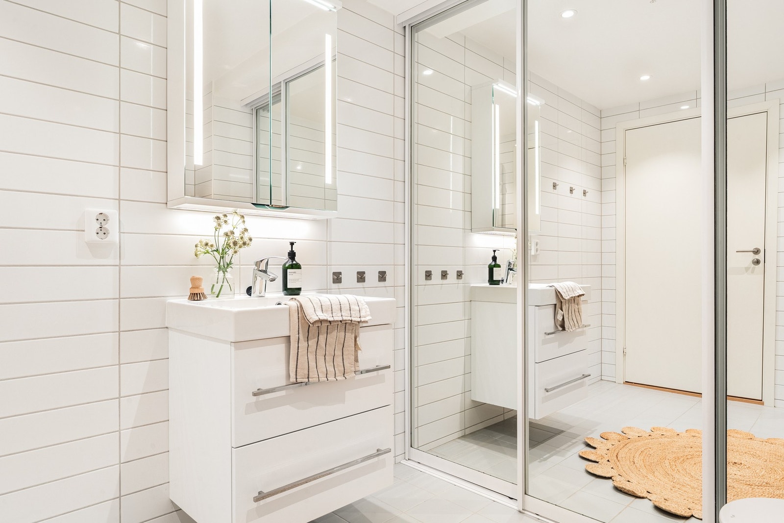 Badet har baderomsinnredning, speil med lys, dusj med innfellbare dører og vegghengt toalett. Galleribilde