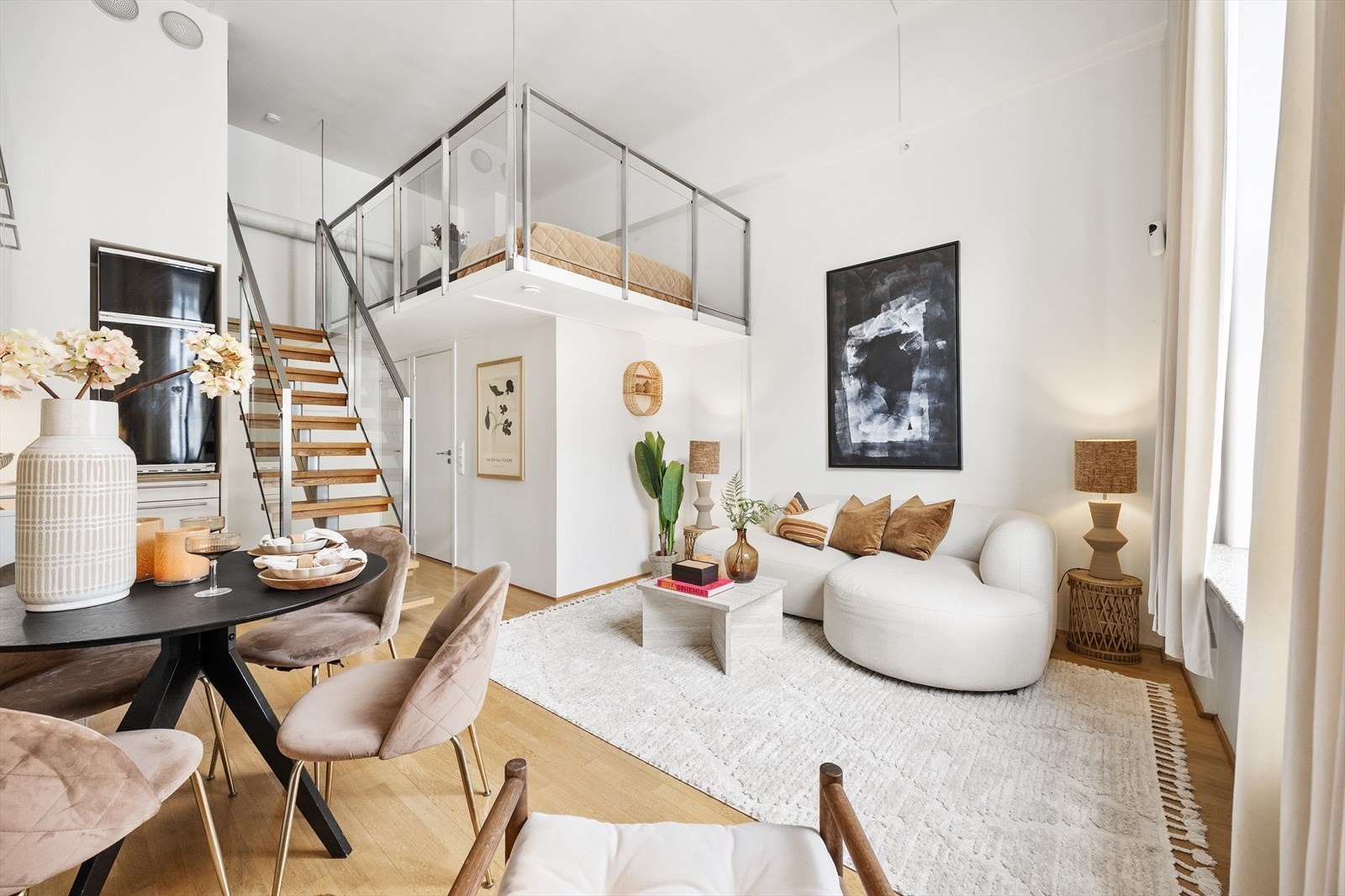 Et helhetlig overblikk som viser hvordan stue, kjøkken og mesanin er bundet sammen i en åpen og luftig romløsning. Galleribilde