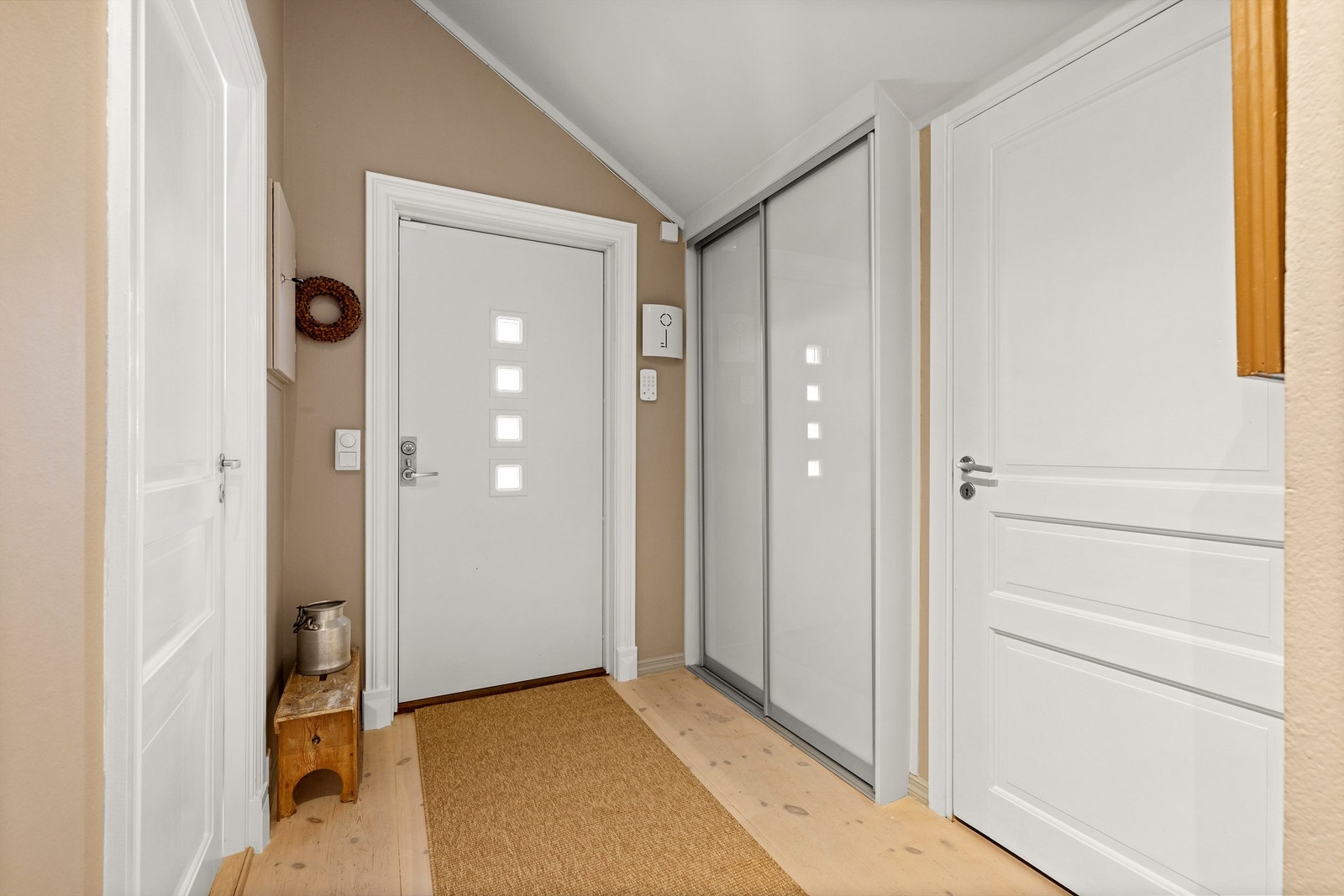 Praktisk skyvedørsgarderobe i entréen gir god plass til oppbevaring av yttertøy. Ytterdøren er fra 2015. Galleribilde