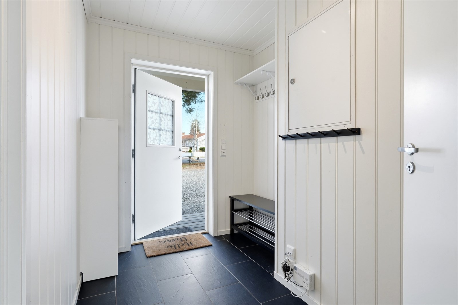 Entré med flislagt gulv og plass til å henge fra seg yttertøy. Galleribilde