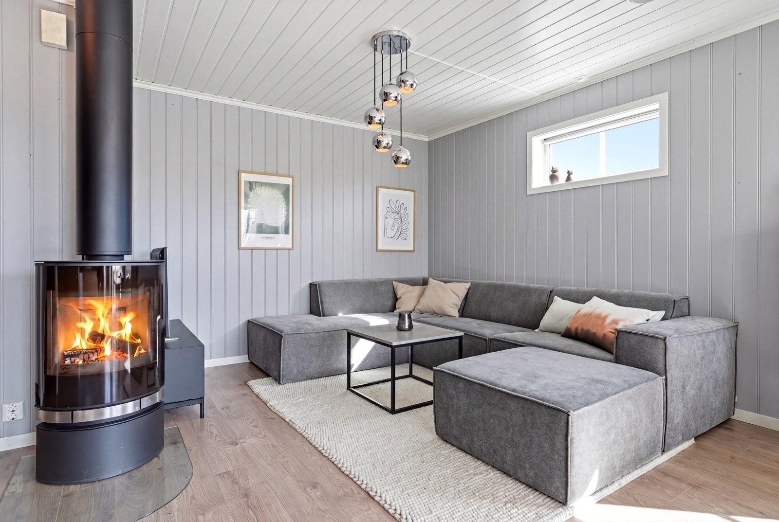 En stemningsskapende peisovn med stålpipe er et sentralt element i stuen. Galleribilde