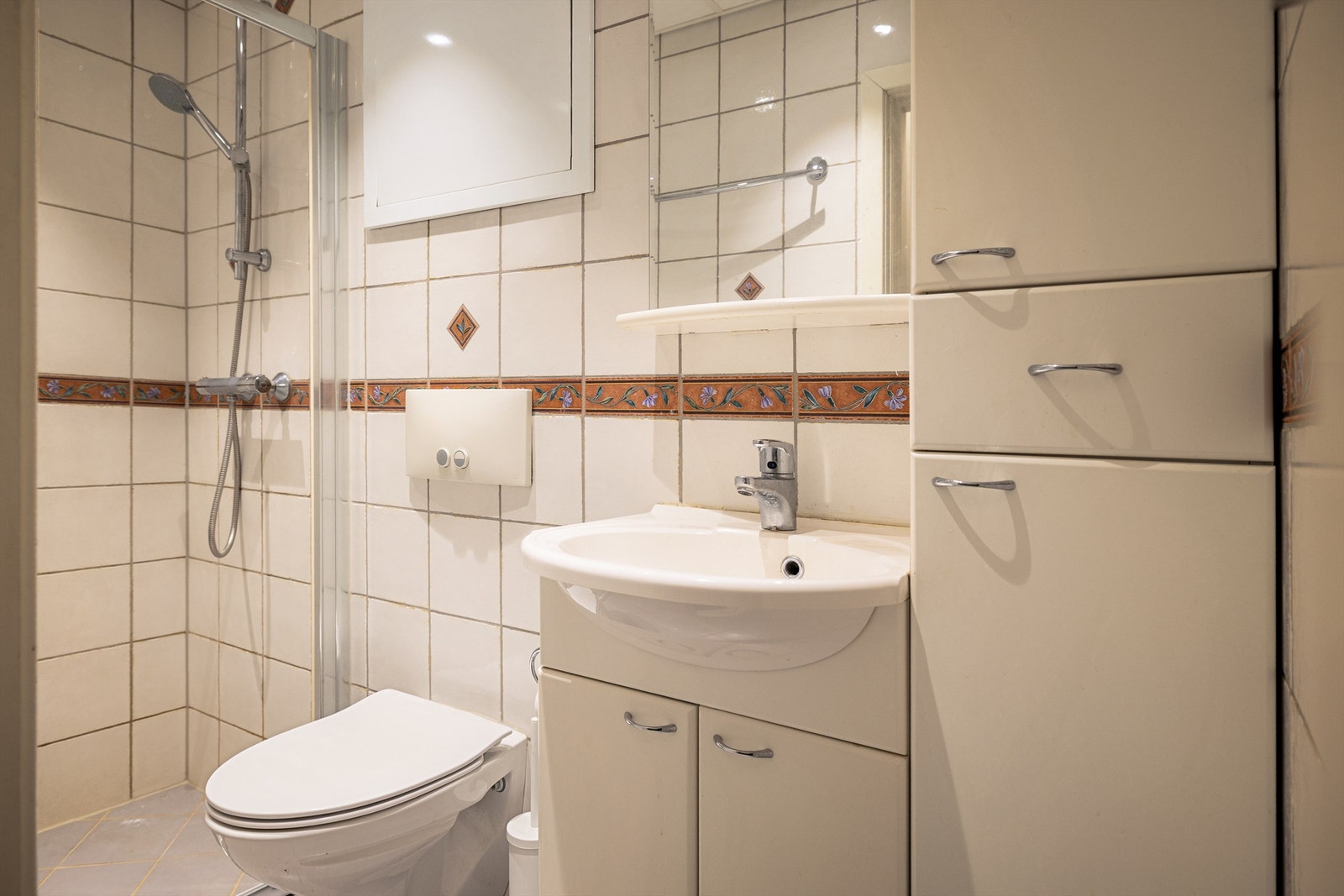 Badet er innredet med vegghengt toalett og servantinnredning. Himlingen har innfelte downlights, og det er mekanisk avtrekk. Galleribilde